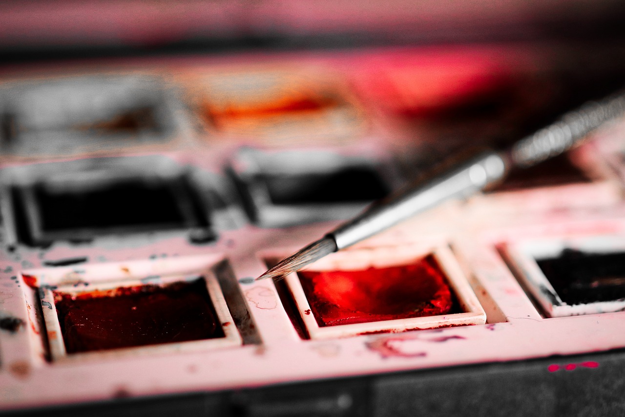 Pensel liggandes på en palett med akvarellfärger