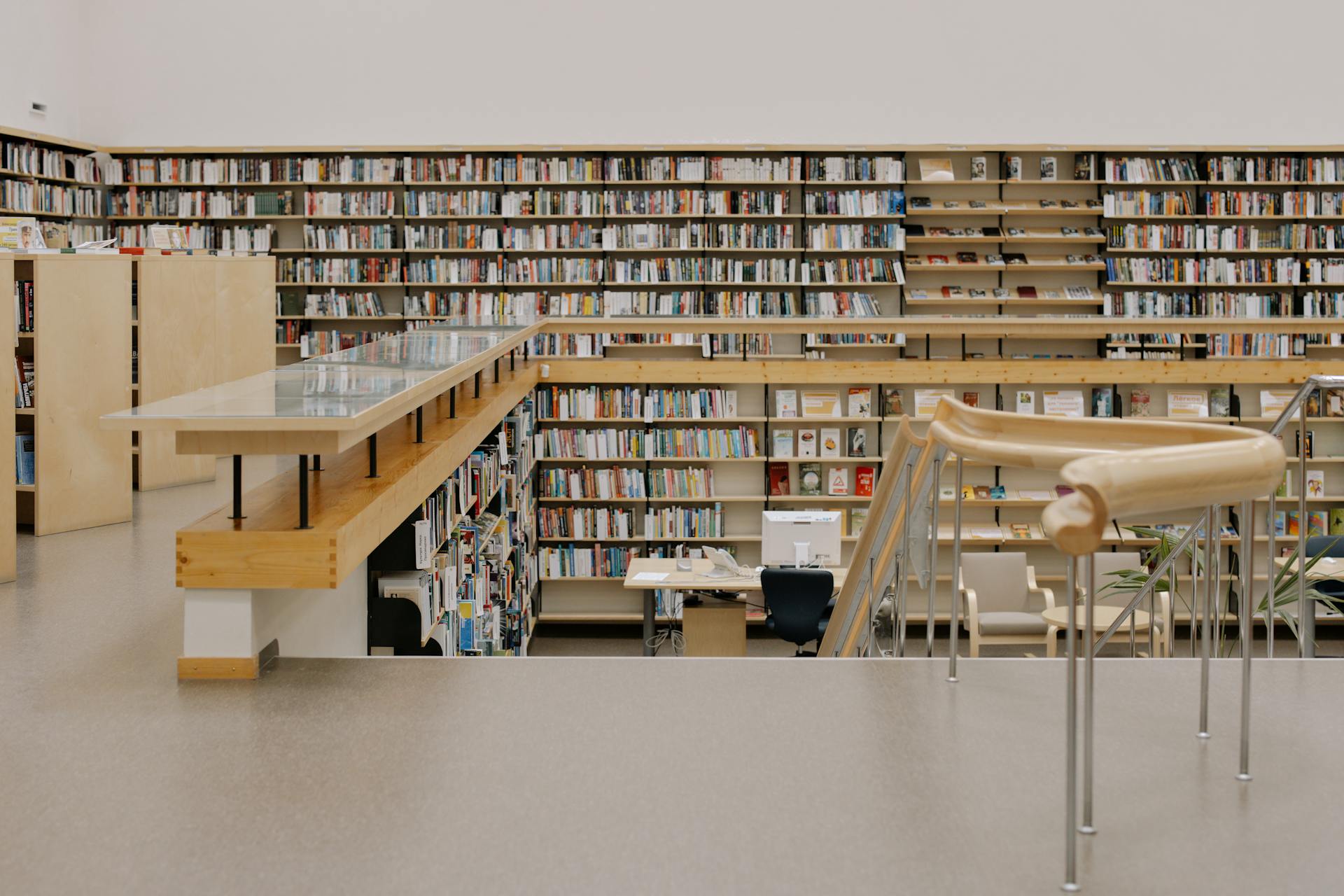 Utsikt över ett stort bibliotek strax framför en trappa ner.
