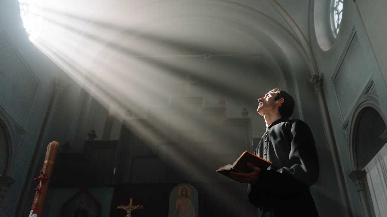 Man med bibel i en kyrka.