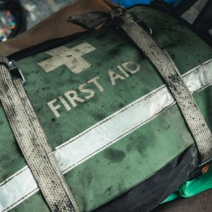 Grön förbandsväska som det står "First aid" på