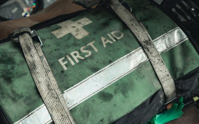 Grön förbandsväska som det står "First aid" på