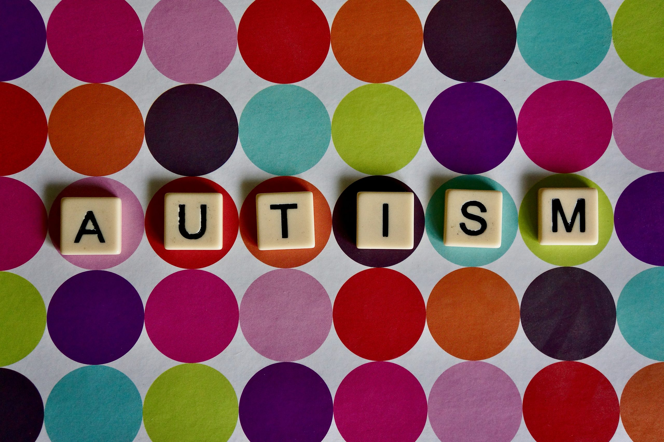 Texten autism på en flerfärgad prickig bakgrund