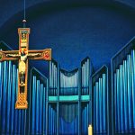 Krucifix framför orgelpipor.