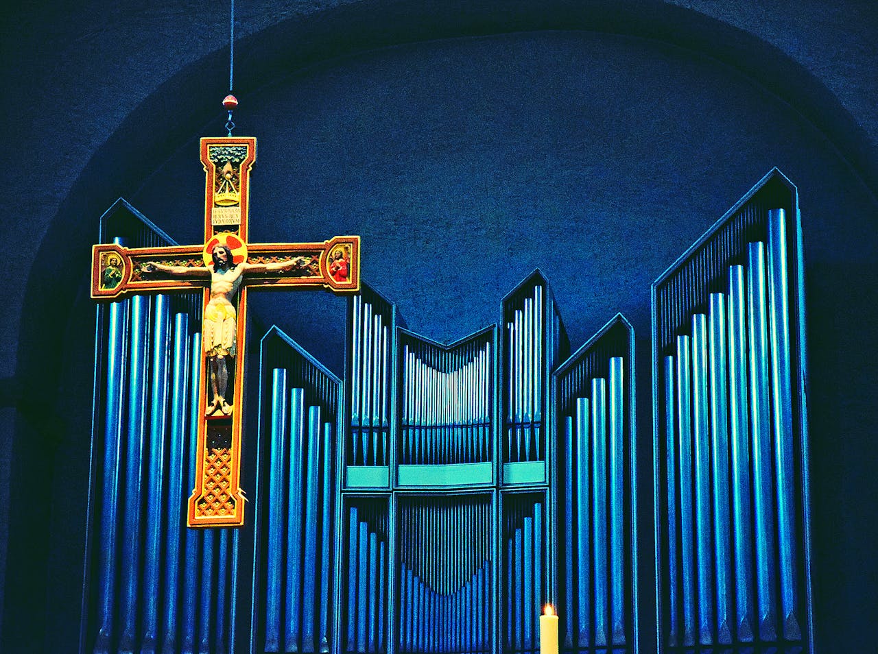 Krucifix framför orgelpipor.