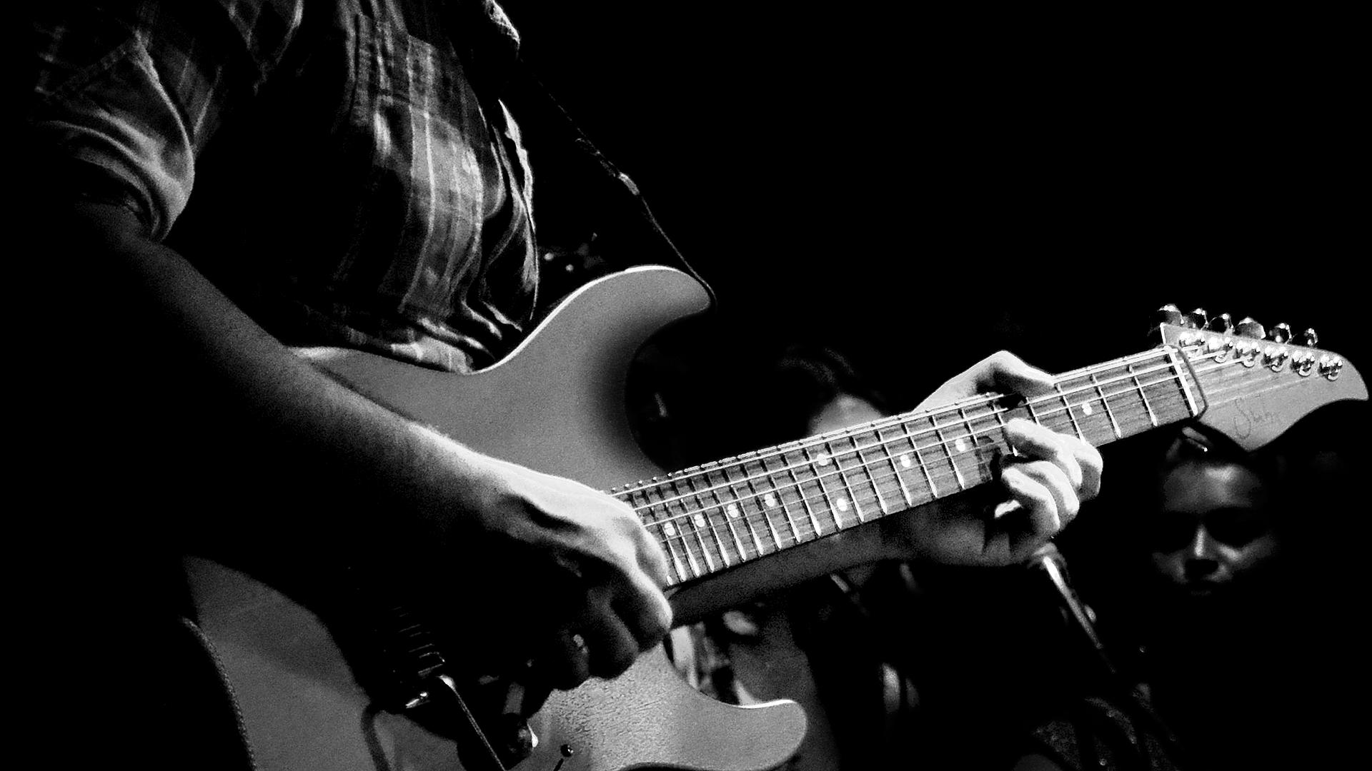 Svartvit bild på en gitarrist som jammar.