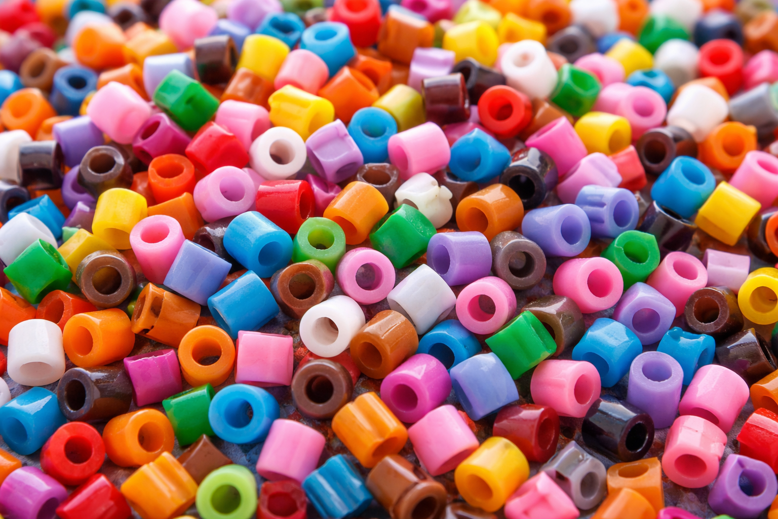 Bild på massor av nabbipärlor i olika färger, bland annat rosa, orange, lila, blå, brun osv.