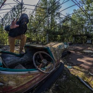 Man i gasmask på förfallet tivoli. In the Zone of Alienation