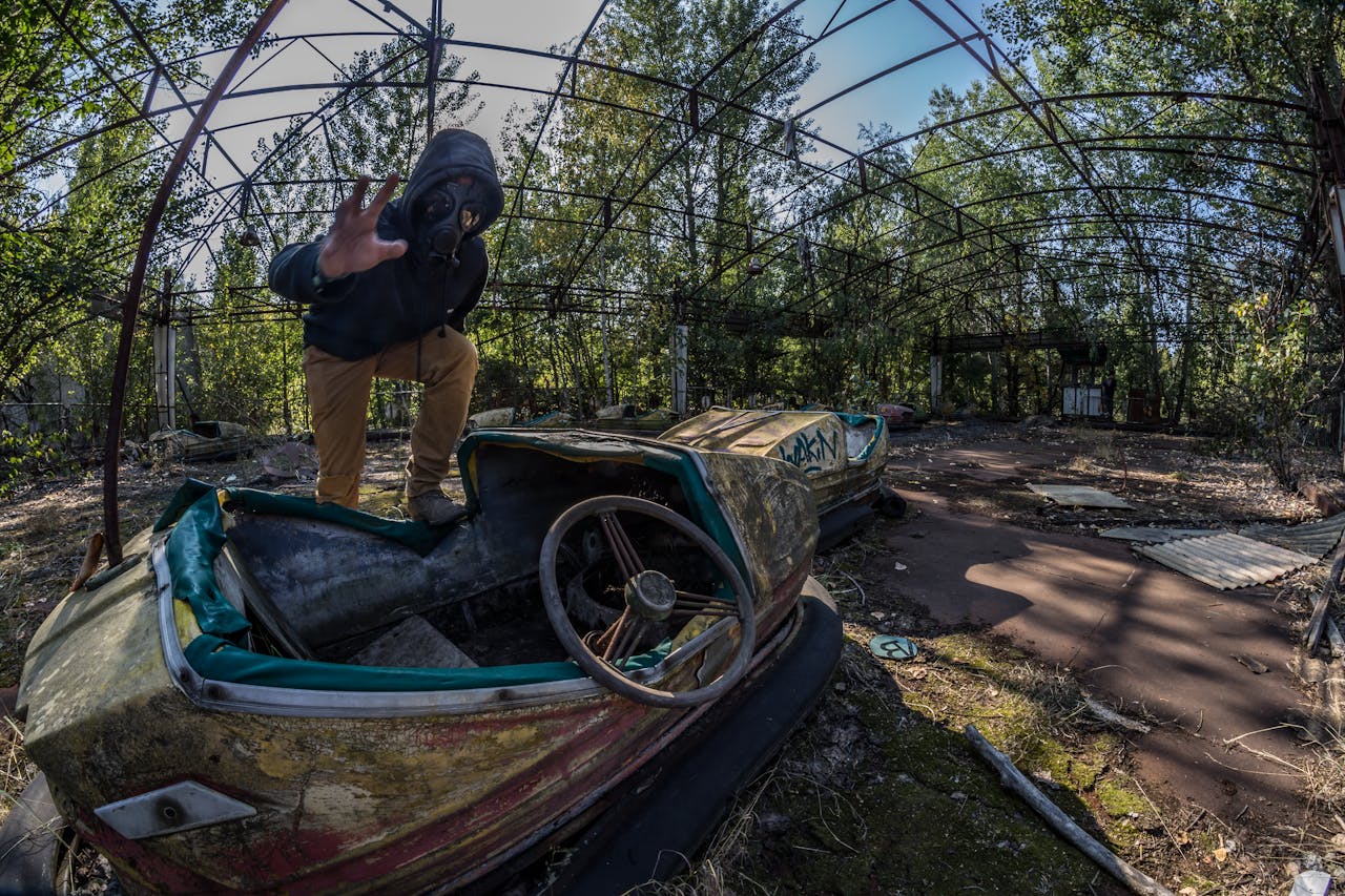 Man i gasmask på förfallet tivoli. In the Zone of Alienation