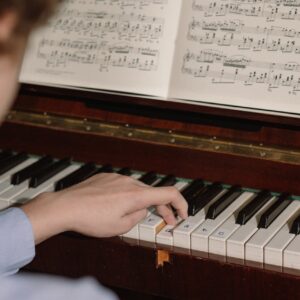 En hand över tangenterna på ett piano.