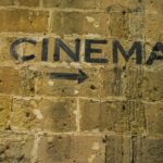 Pil mot bioingång på murad vägg.