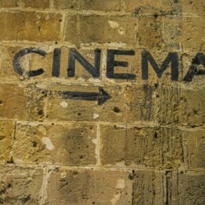 Pil mot bioingång på murad vägg.