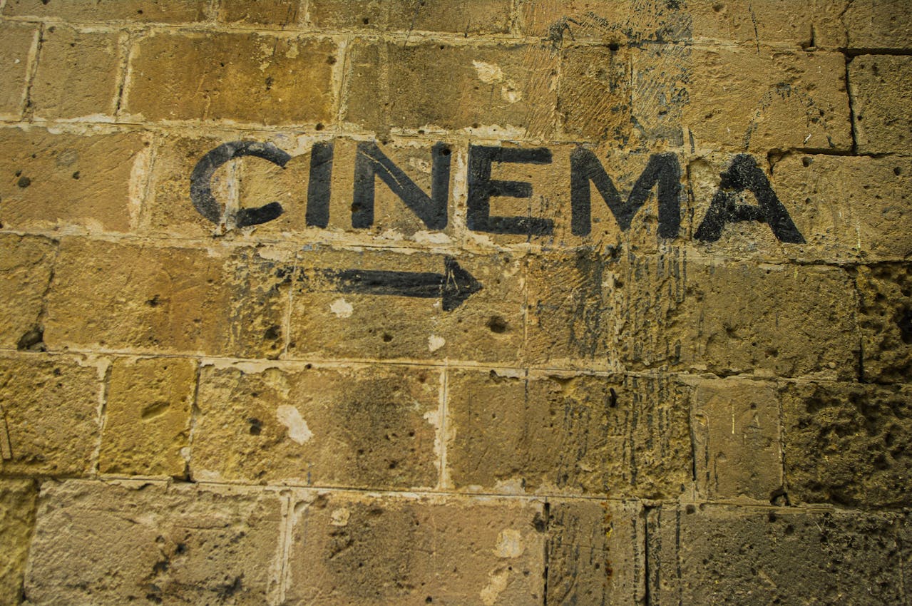 Pil mot bioingång på murad vägg.