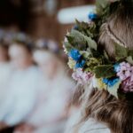 Bild på en midsommarkrans på en persons huvud.