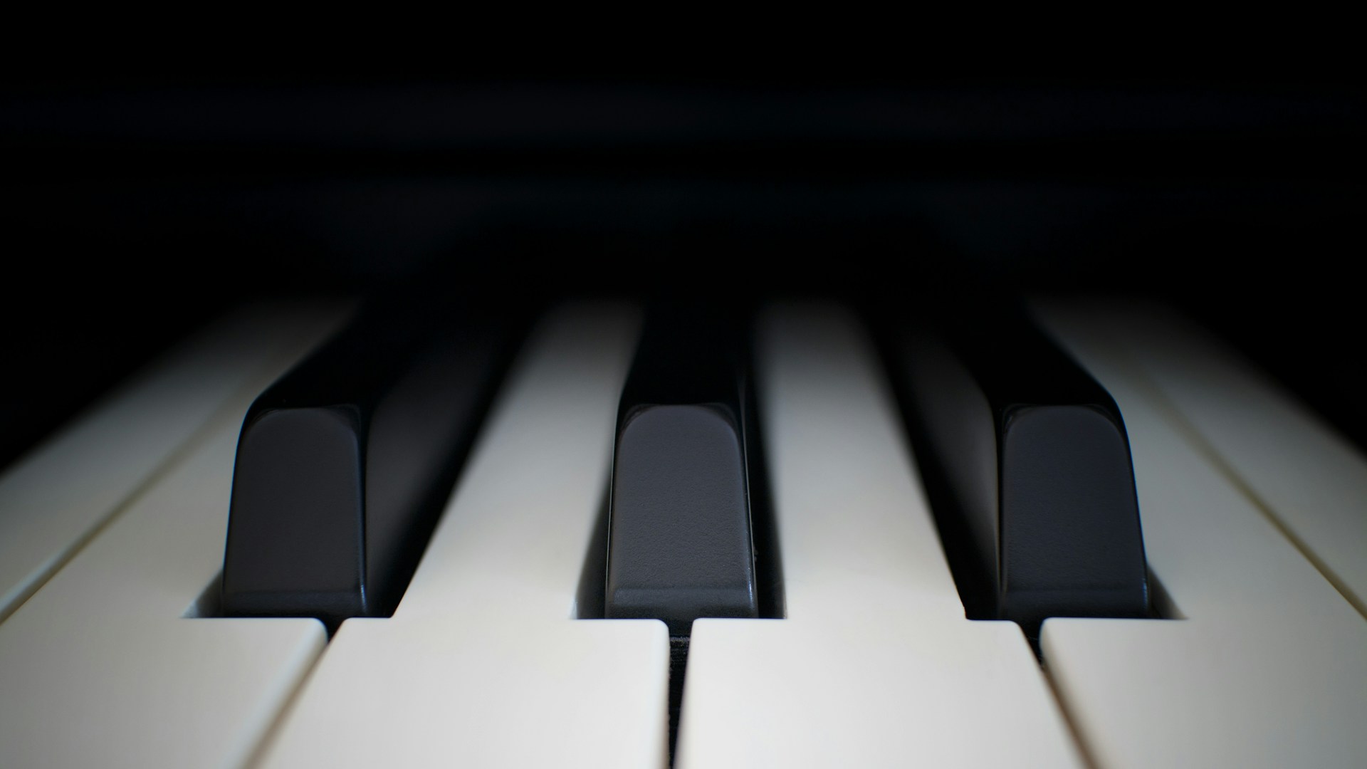 Foto i närbild av tangenterna på ett piano.