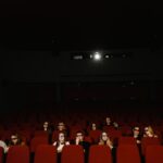 Biografbesökare som sitter på sina platser i en nedsläckt biograf.