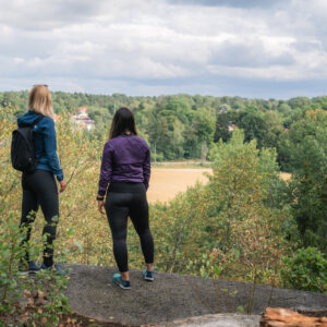 Bild på två personer som står ute i naturen.