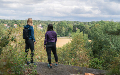 Bild på två personer som står ute i naturen.