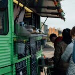 Personer som står i led för att handla mat från en foodtruck.