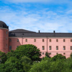 Bild av slottet i Uppsala på sommaren.