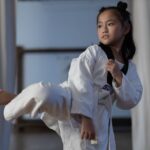 Flicka i 10-års åldern som genomför en Taekwondospark.