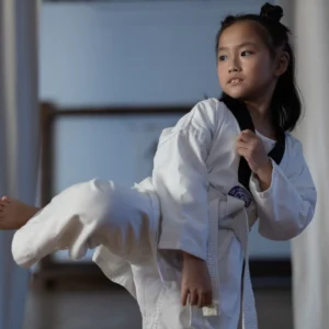 Flicka i 10-års åldern som utför Taekwondo