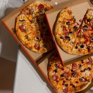 Bild på tre pizzor i öppna pizzakartonger.