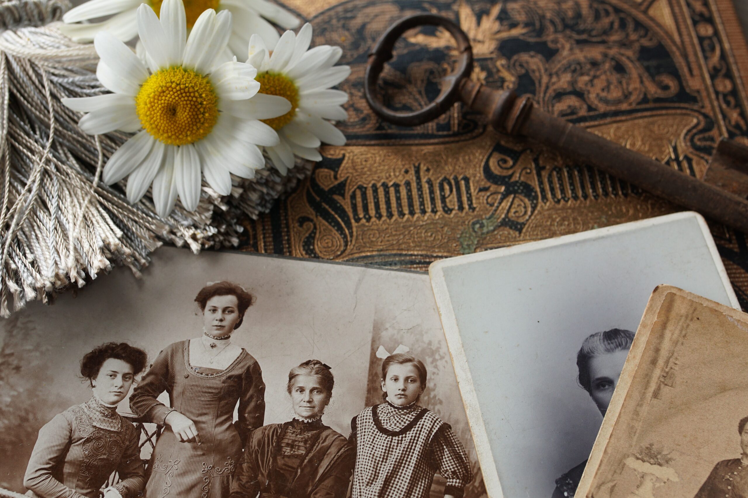Gamla familje fotgrafier med prästkragar bredvid och en gammal nyckel