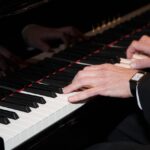 närbild på två händer som spelar piano