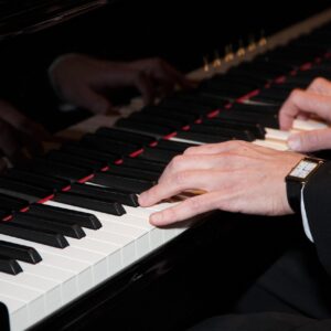 närbild på två händer som spelar piano