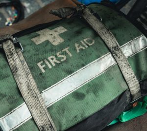 Grön förbandsväska som det står "First aid" på